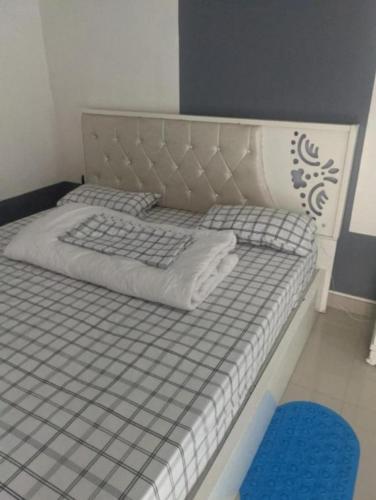 a bed with a gray and white bed frame and a blue rug at Ignite guest house in Gisenyi