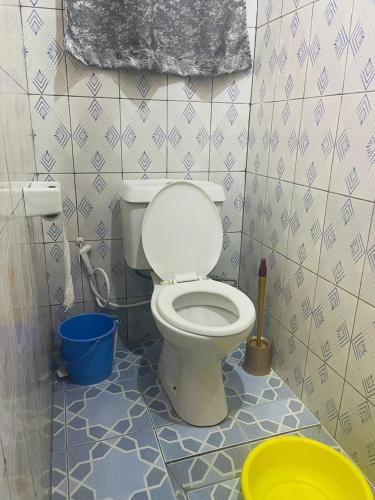 a bathroom with a toilet and a bucket at Ignite guest house in Gisenyi