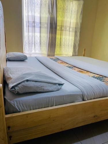 two twin beds in a room with a window at Ignite guest house in Gisenyi