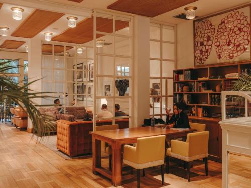 a library with people sitting at a table in a room at Hotel Pulitzer Barcelona in Barcelona