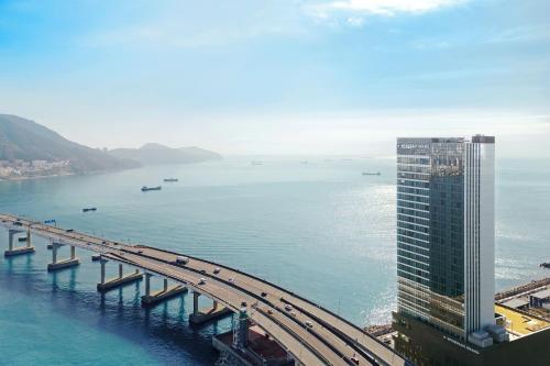 a bridge over a body of water with a tall building at Wyndham Grand Busan in Busan