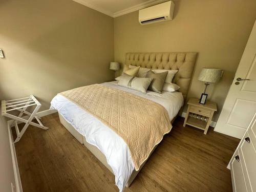 1 dormitorio con 1 cama grande con sábanas y almohadas blancas en Mountain View 1-Bedroom Villa in Franschhoek en Franschhoek