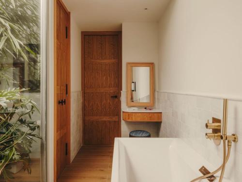 a bathroom with a sink and a mirror and a tub at Hotel Pulitzer Barcelona in Barcelona