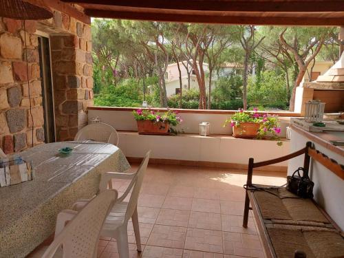 un patio con tavolo, sedie e finestra di La Perla al mare 300mt from Perla Marina Beach a Santa Margherita di Pula