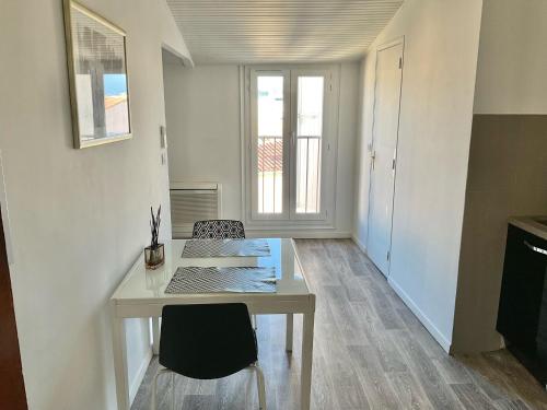 une chambre blanche avec une table et deux chaises dans l'établissement T2 Tout confort centre ville, à Ajaccio