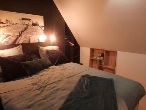 una camera da letto con un grande letto con un'immagine appesa alla parete di Ateljee Sohie a Hoeilaart