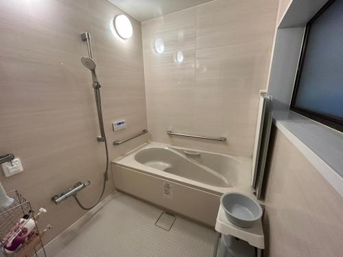 a bathroom with a bath tub and a toilet at Guest House Uminokyojyusya - Vacation STAY 83084v in Miyazaki