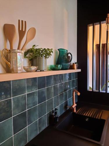 a kitchen with a sink and a shelf with utensils at Ateljee Sohie in Hoeilaart