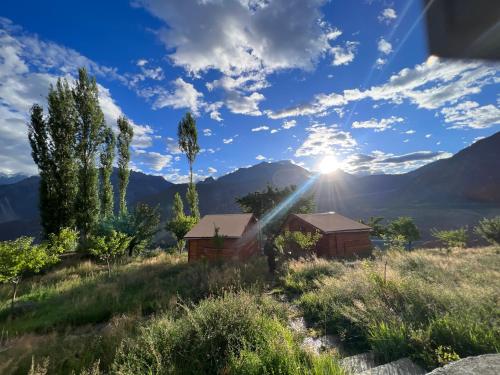 a view of the sun setting over the mountains at Destination Lodges Camp Leo Hoppar Valley in Gilgit