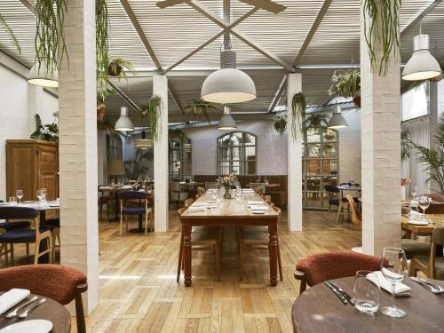 a dining room with tables and chairs in a restaurant at Hotel Pulitzer Barcelona in Barcelona