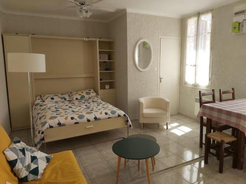 1 dormitorio con 1 cama, 1 mesa y 1 silla en Le Rove : la petite maison en Le Rove