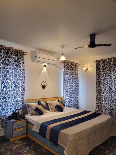 een slaapkamer met een bed met blauwe en witte gordijnen bij The Bayt in Srinagar