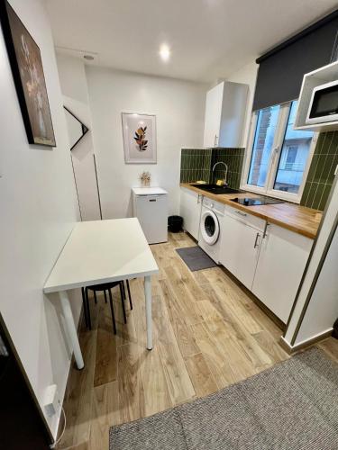 - une cuisine avec une table blanche et un évier dans l'établissement Studio spacieux refait à neuf (4), à Saint-Ouen