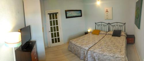1 dormitorio con 1 cama y TV de pantalla plana en AlmenaraLove See Watching, en Lastres