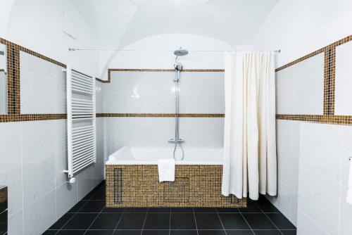 Das Bad ist mit einer Badewanne und einer Dusche ausgestattet. in der Unterkunft Golden Well in Prag