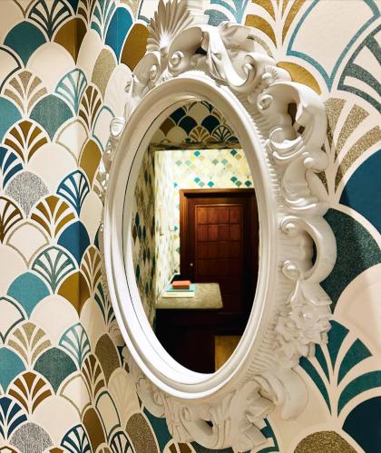 a mirror on a wall with blue and white wallpaper at Palazzina300 in Treviso