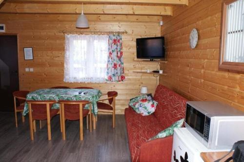 a living room with a table and a couch and a tv at Two storey holiday houses for 4 people Jaros awiec in Jarosławiec