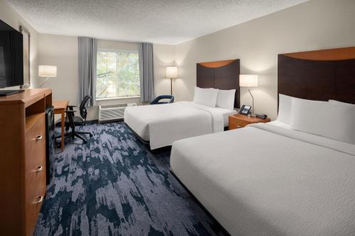 a hotel room with two beds and a flat screen tv at Fairfield Inn & Suites Portland West Beaverton in Beaverton