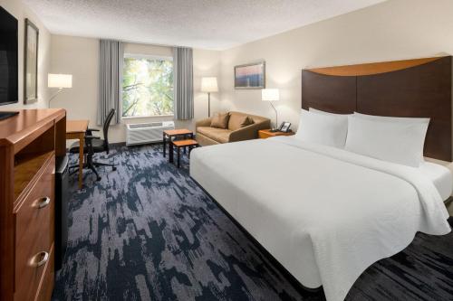 a hotel room with a large bed and a living room at Fairfield Inn & Suites Portland West Beaverton in Beaverton