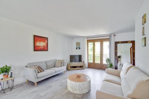 a living room with two couches and a tv at Spacious house with garden in Neuilly-sur-Marne