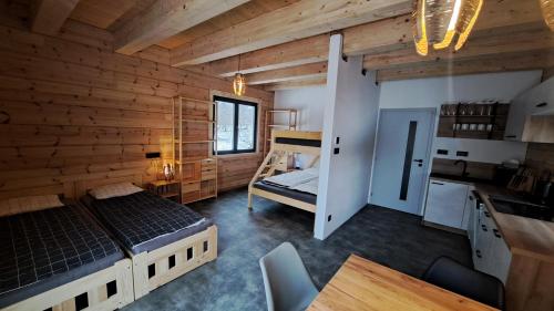 a bedroom with a bed and a desk and a kitchen at wellness roubenka Holčí in Miřetice