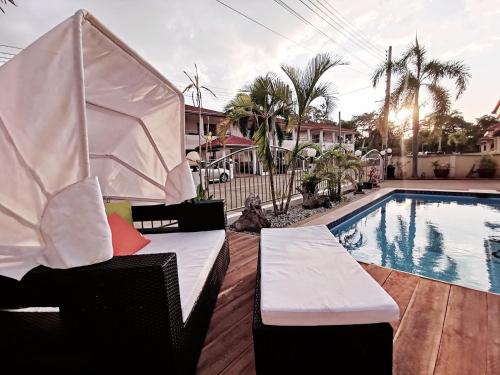 a pool with two chairs next to a swimming pool at Pool Villa 92 in Ban Nong Pru