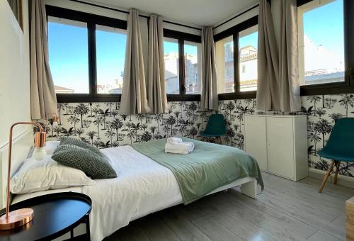 - une chambre avec un lit, 2 chaises et des fenêtres dans l'établissement NOCNOC Le Capucin, à Marseille