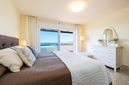 a bedroom with a large bed with a large window at Dúplex de Lujo Marbella Golf in Marbella