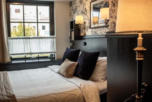 a bedroom with a bed with two pillows and two windows at Hotel & Ristorante Bellora in Gothenburg