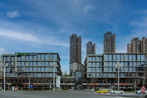 ein großes Gebäude mit hohen Gebäuden in einer Stadt in der Unterkunft Holiday Inn Express Chongqing Nanbin Road, an IHG Hotel in Chongqing