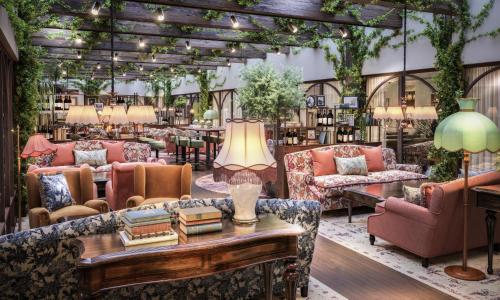 ヨーテボリにあるホテル ＆ リストランテ ベローラのソファ、テーブル、植物のある部屋