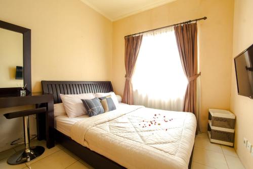 - une chambre avec un lit, un bureau et une fenêtre dans l'établissement Sudirman Park Apartment, à Jakarta