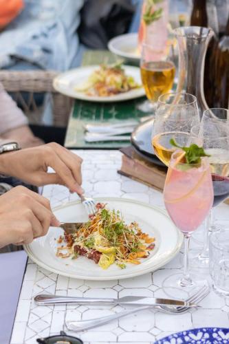 a table with a plate of food and glasses of wine at Hotel Pigalle in Gothenburg