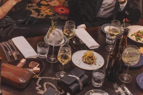 a table with glasses of wine and a plate of food at Hotel Pigalle in Gothenburg