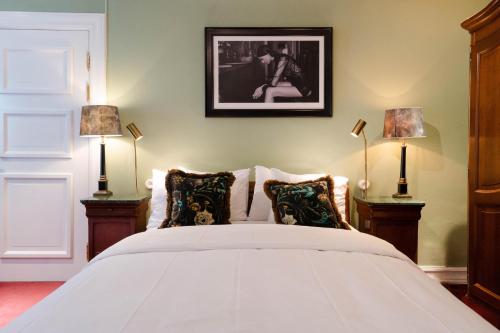a bedroom with a white bed with two lamps at MJ's in Malmö