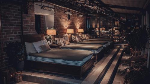 a row of beds in a room with a brick wall at Steam Hotel in Västerås