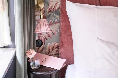 a bedroom with a bed and a table with a lamp at MJ's in Malmö