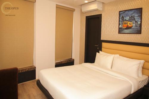 a bedroom with a white bed in a room at The Opus Kolkata - A Boutique Hotel in Kolkata