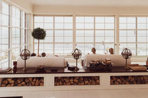 una habitación con dos personas sentadas en sofás frente de las ventanas en Ystad Saltsjöbad, en Ystad