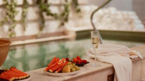 a table with a plate of fruit and a glass of wine at Falkenberg Strandbad in Falkenberg