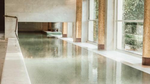 a pool of water in a room with windows at Falkenberg Strandbad in Falkenberg