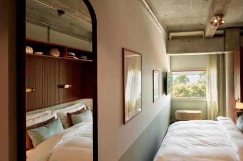 a bedroom with two beds and a mirror at Ellery Beach House in Lidingö