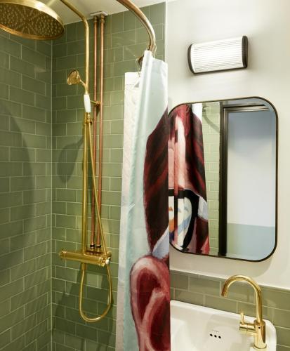 a bathroom with a shower and a sink with a mirror at Ellery Beach House in Lidingö