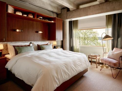 a bedroom with a large white bed and a window at Ellery Beach House in Lidingö