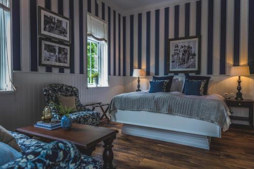 a bedroom with a bed and a chair and a table at Villa Strandvägen in Ystad