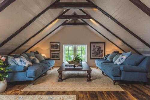 una sala de estar con 2 sofás azules y una mesa. en Villa Strandvägen, en Ystad