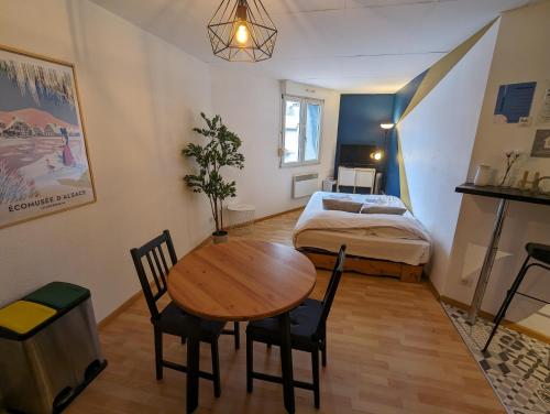 ミュルーズにあるTon Petit Studio - Le 62 - Coeur de Villeのテーブルとベッド付きの小さな部屋