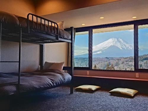 a bedroom with a bunk bed and a mountain view at Rokumeikan Hills in Yamanakako