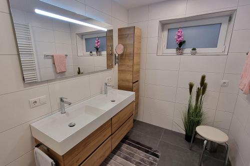 La salle de bains blanche est pourvue d'un lavabo et d'un miroir. dans l'établissement Ferienwohnung Tahedl, à Wegscheid