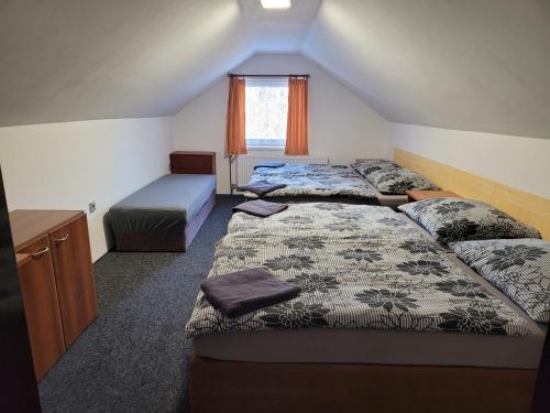 sypialnia z 2 łóżkami i oknem w obiekcie Penzion Karolína w mieście Lučany nad Nisou